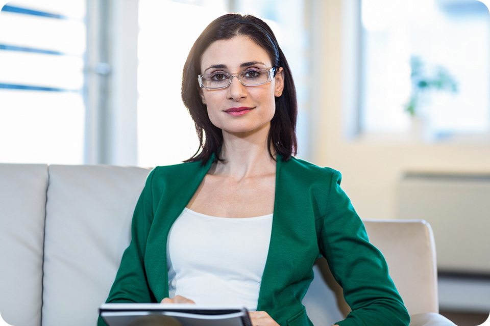 A woman in a green blazer sits on a sofa, holding a notebook, representing professional service SMEs (e.g., consulting, finance). ccMonet’s AI - powered financial tools (bookkeeping, dashboards) and industry - tailored services, plus expert support (tax compliance, business registration), help such businesses manage finances efficiently.